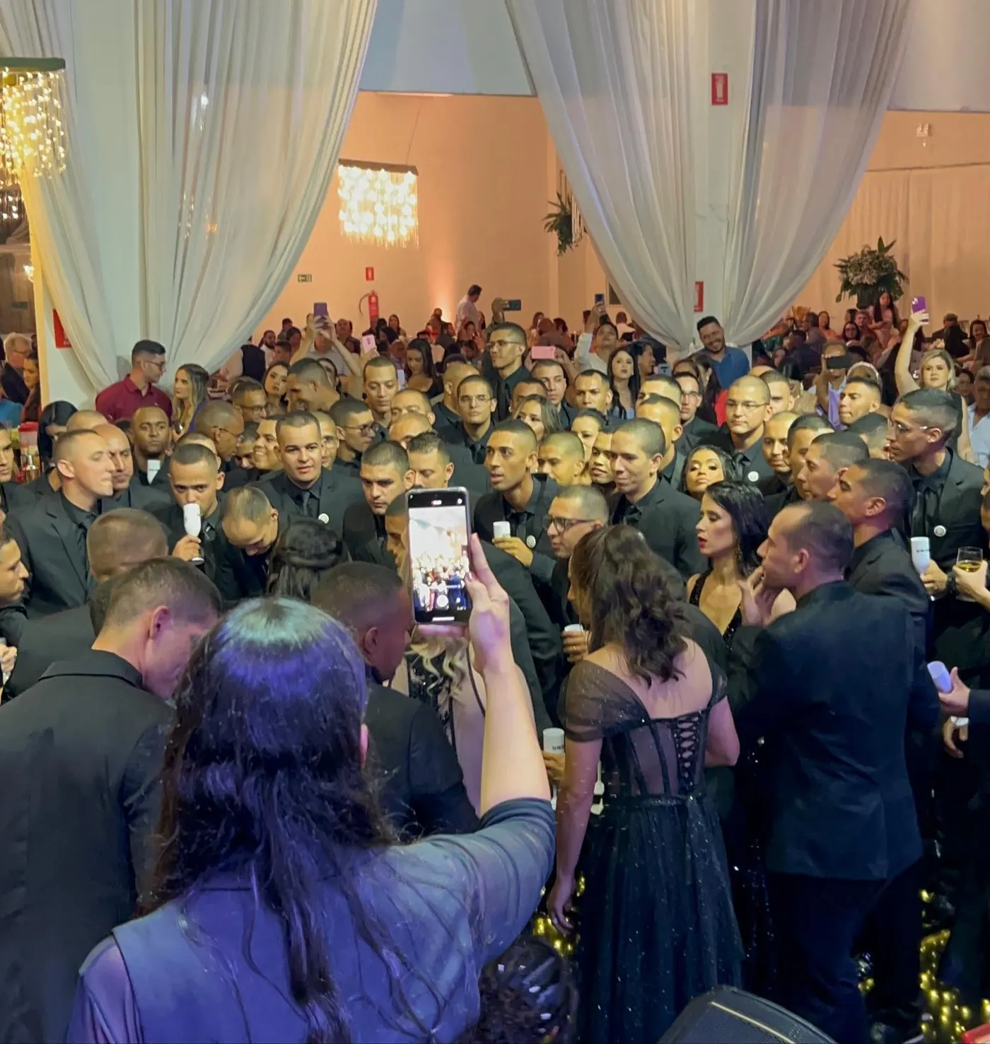 Salão de formatura lotado com painel de LED e luzes de moving