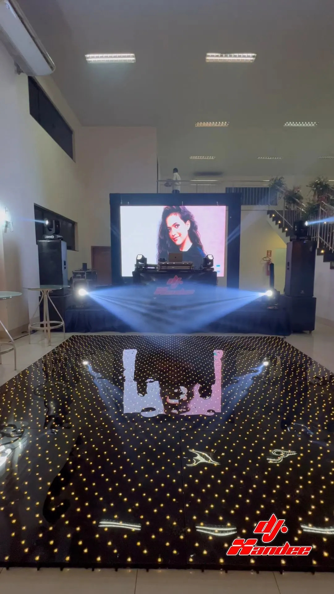 Painel de LED mostrando a foto da debutante atrás da pista de LED