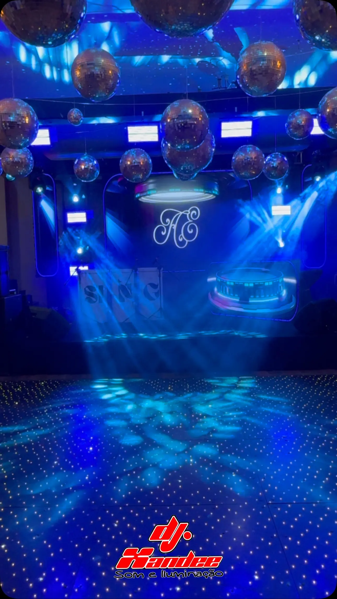 Pista de LED azul com movings, globos espelhados e a logo DJ Xandee no piso
